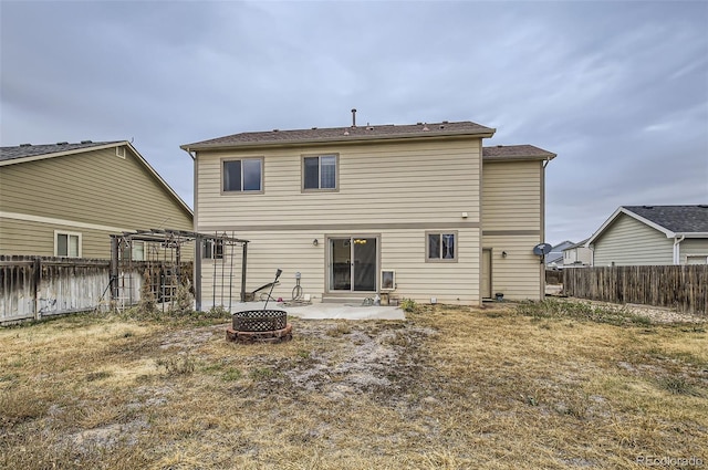 rear view of property with a fire pit and a patio