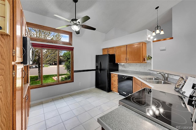 kitchen featuring a sink, ceiling fan with notable chandelier, high vaulted ceiling, black appliances, and light tile patterned floors