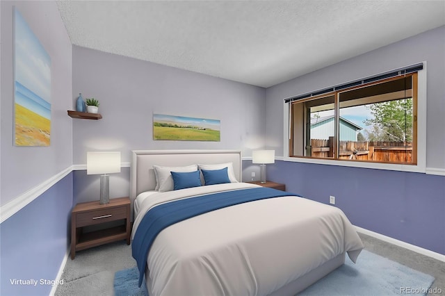 bedroom with carpet, a textured ceiling, and baseboards