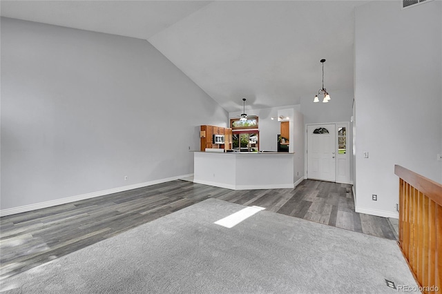 unfurnished living room featuring baseboards, dark wood finished floors, and high vaulted ceiling