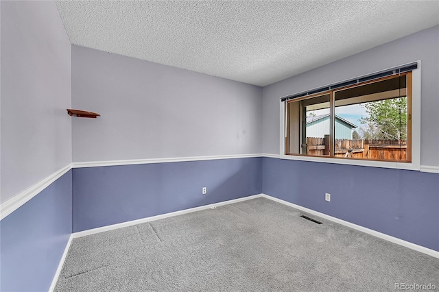 unfurnished room featuring a textured ceiling, visible vents, baseboards, and carpet floors