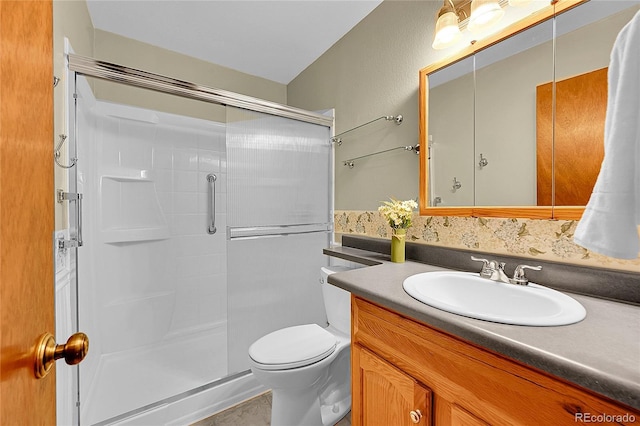 bathroom featuring vanity, toilet, and a shower stall