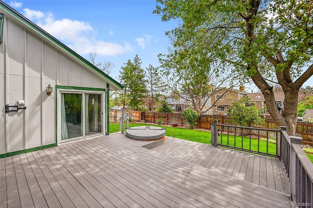 wooden terrace with a lawn and a fenced backyard