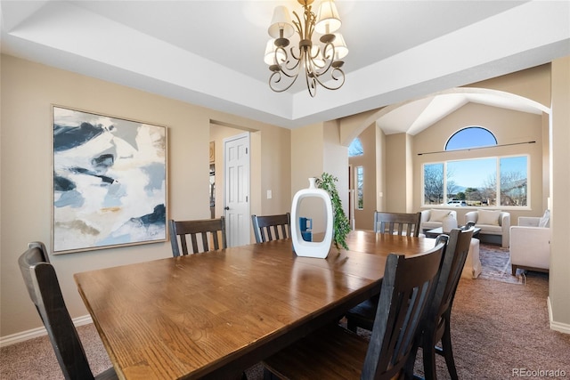 dining space with an inviting chandelier, a raised ceiling, and carpet floors