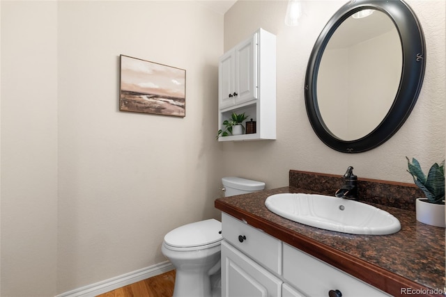 bathroom featuring toilet, vanity, and wood-type flooring