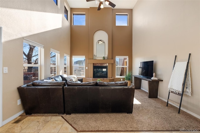 living room featuring ceiling fan and a towering ceiling