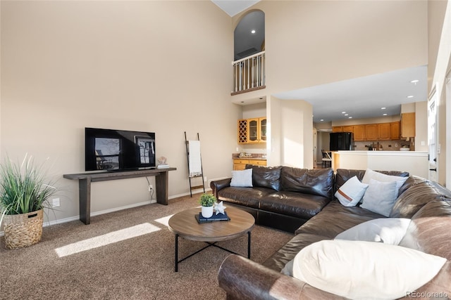 carpeted living room with a high ceiling