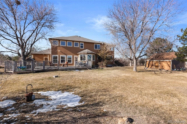 rear view of house featuring a deck and a yard