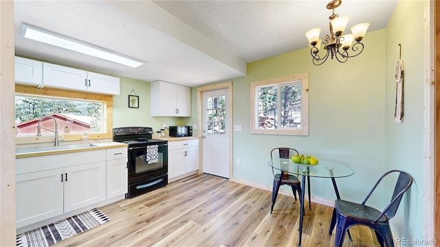 60 Ball Rd, Bailey, CO 80421 - kitchen featuring black appliances, a sink, light wood finished floors, white cabinetry, and a chandelier