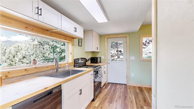 60 Ball Rd, Bailey, CO 80421 - kitchen with black range oven, dishwashing machine, light wood finished floors, a sink, and white cabinets