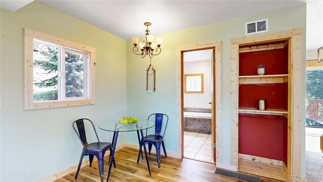 60 Ball Rd, Bailey, CO 80421 - dining space featuring wood finished floors, healthy amount of natural light, a chandelier, and baseboards