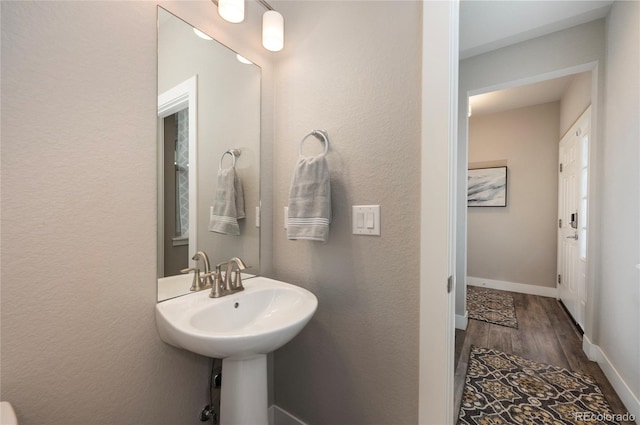 bathroom with baseboards and wood finished floors