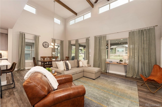 living room featuring baseboards, beamed ceiling, ceiling fan with notable chandelier, wood finished floors, and high vaulted ceiling