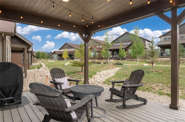 wooden deck featuring a lawn, a residential view, and area for grilling