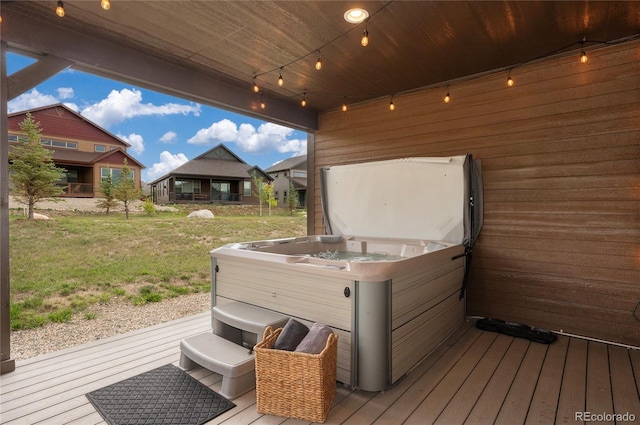 wooden terrace featuring a hot tub and a yard