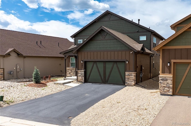 craftsman house with board and batten siding, driveway, stone siding, and a garage