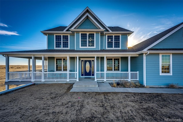 view of front of home with covered porch and roof with shingles