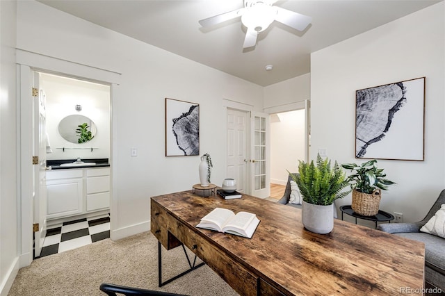 home office featuring light floors, a ceiling fan, and a sink