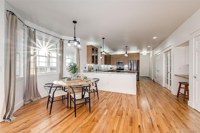 dining space featuring light wood-style flooring and baseboards