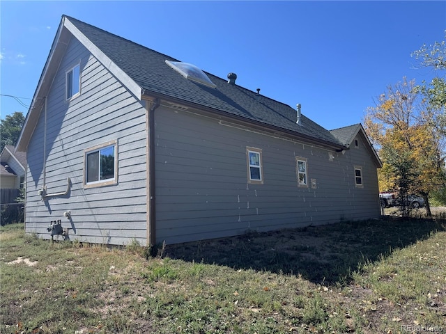view of side of property featuring a shingled roof