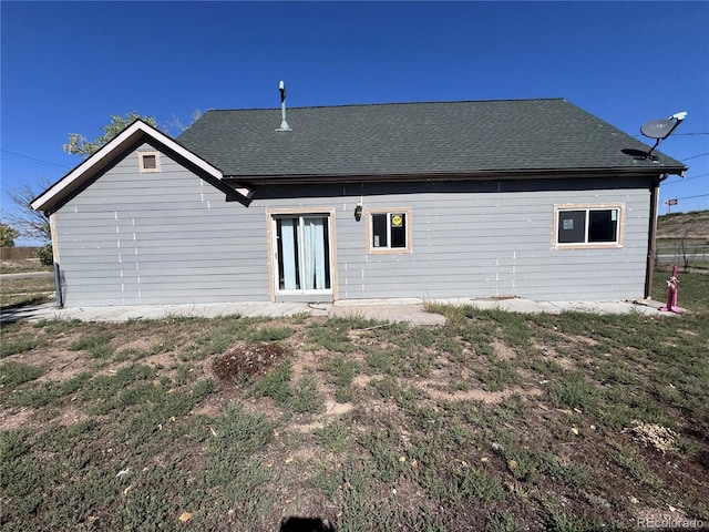 back of house with roof with shingles