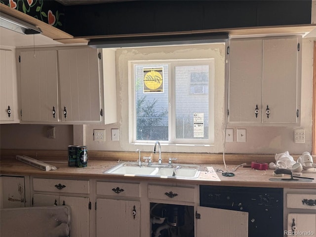 kitchen with a sink, light countertops, white cabinetry, and black dishwasher
