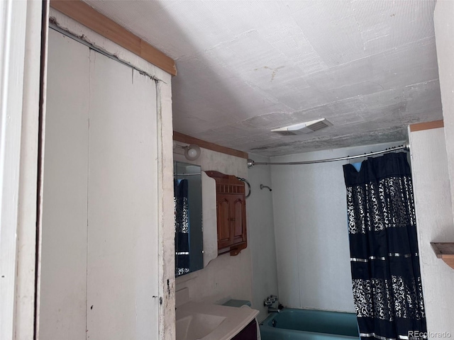 full bath featuring vanity, shower / tub combo with curtain, and visible vents