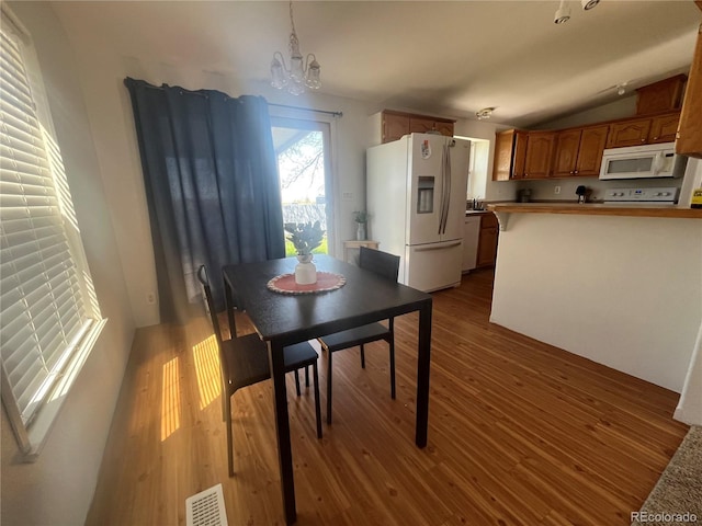 235 Marion St, Burlington, CO 80807 - dining room featuring wood finished floors, a chandelier, and lofted ceiling