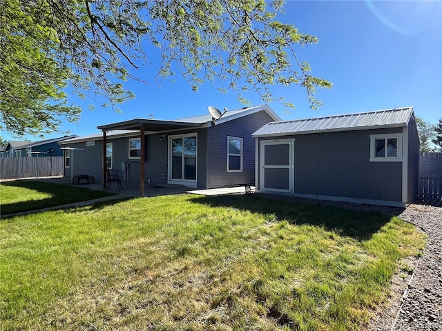 235 Marion St, Burlington, CO 80807 - back of house with an outdoor structure, metal roof, a patio area, and a shed