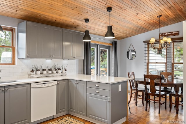 110 County Road 652, Grand Lake, CO 80447 - kitchen with white dishwasher, gray cabinetry, a peninsula, a chandelier, and decorative backsplash