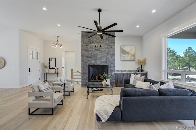 16510 Early Light Dr, Colorado Springs, CO 80908 - living room featuring a fireplace, baseboards, ceiling fan with notable chandelier, recessed lighting, and light wood-style flooring