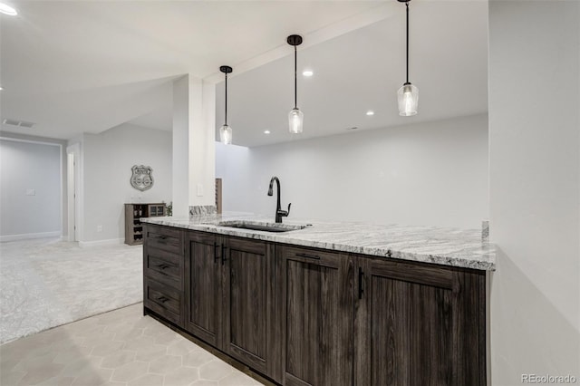 16510 Early Light Dr, Colorado Springs, CO 80908 - kitchen with dark brown cabinets, light colored carpet, a sink, light tile patterned floors, and visible vents