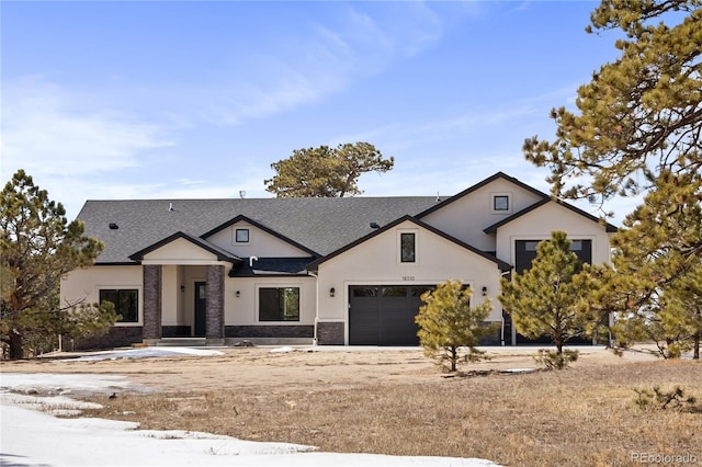 16510 Early Light Dr, Colorado Springs, CO 80908 - view of front of home with stucco siding, a garage, roof with shingles, and stone siding