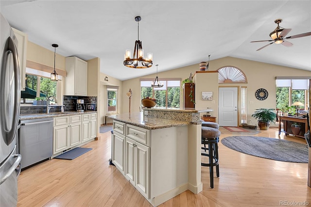 10786 Marclif Rd, Conifer, CO 80433 - kitchen with appliances with stainless steel finishes, a kitchen bar, a sink, lofted ceiling, and a chandelier