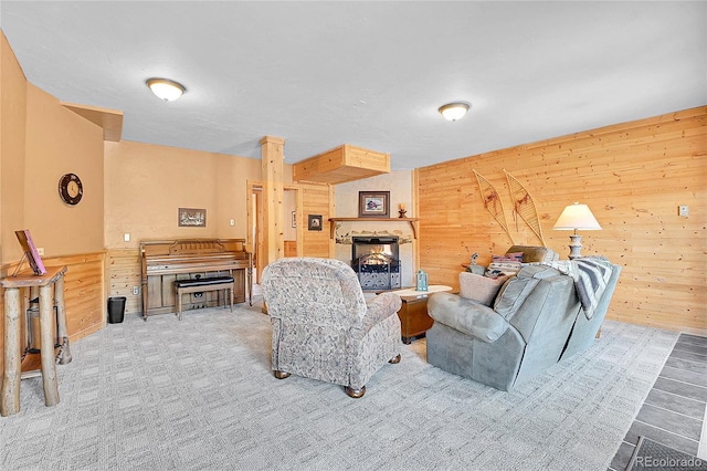 10786 Marclif Rd, Conifer, CO 80433 - living area featuring wooden walls, a lit fireplace, and carpet flooring