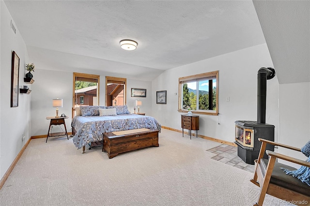 10786 Marclif Rd, Conifer, CO 80433 - carpeted bedroom with baseboards, lofted ceiling, a wood stove, and a textured ceiling