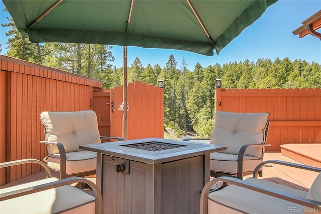 10786 Marclif Rd, Conifer, CO 80433 - view of patio / terrace with an outdoor fire pit, a gate, fence, and a view of trees