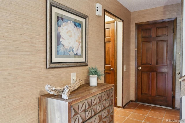 entryway with light tile patterned floors and a textured ceiling