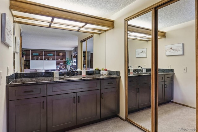 full bath with a textured ceiling and vanity
