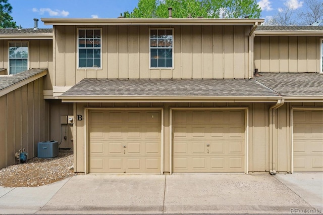 garage with driveway and central AC unit