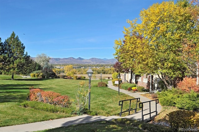 surrounding community with a mountain view and a yard