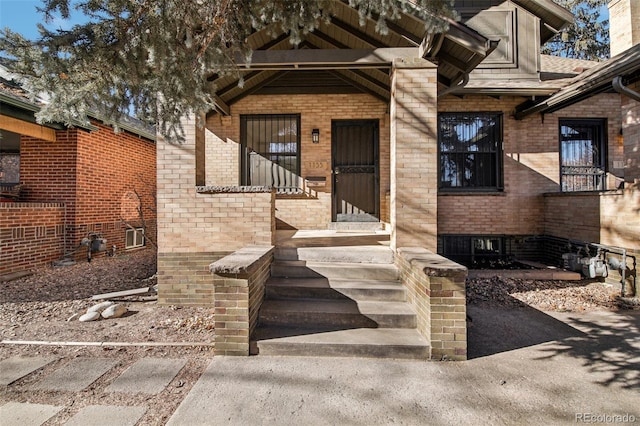 doorway to property with brick siding
