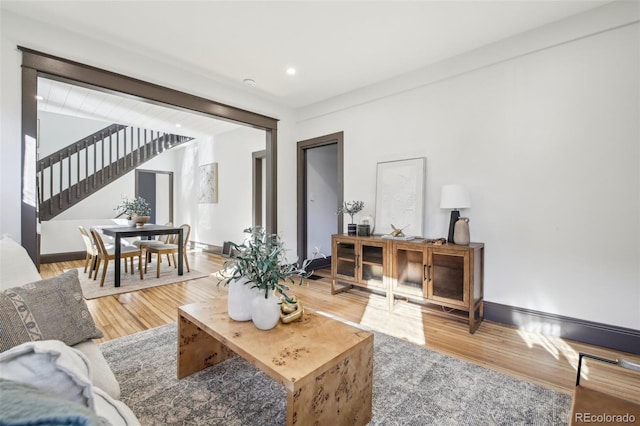 living area featuring stairway, baseboards, and wood finished floors