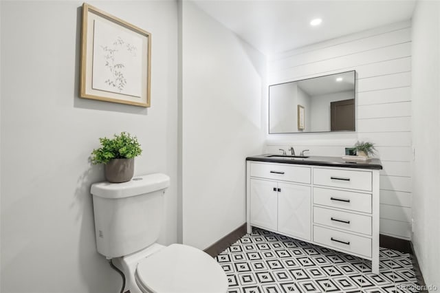 bathroom with toilet, vanity, and baseboards