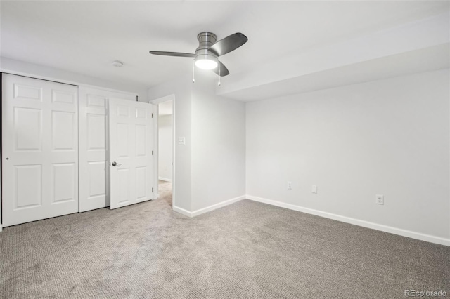 unfurnished bedroom with a closet, baseboards, carpet flooring, and ceiling fan