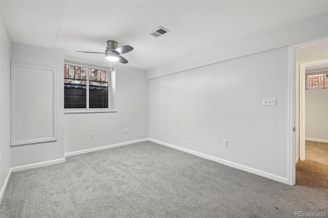 carpeted empty room featuring visible vents, ceiling fan, and baseboards