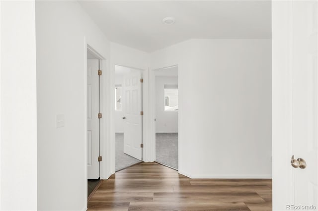 corridor featuring wood finished floors and baseboards