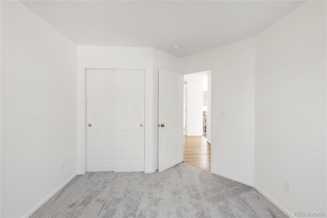 unfurnished bedroom featuring a closet, baseboards, and carpet flooring