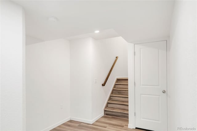 below grade area with recessed lighting, baseboards, stairs, and light wood finished floors