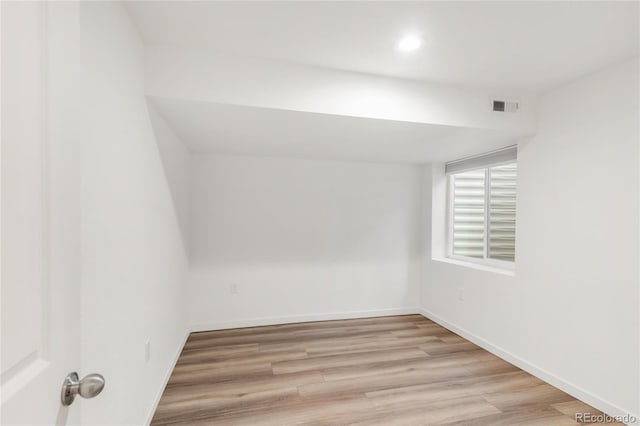 empty room featuring light wood-style flooring, visible vents, and baseboards